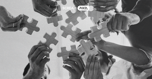 A team holding wooden puzzle pieces symbolizing collaboration and creative solutions.